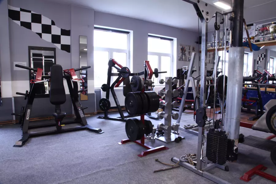 Fitnessstudio neben der Ferienwohnung Plauen: Maschinenpark mit Kraftgeräten vor großen Fenstern