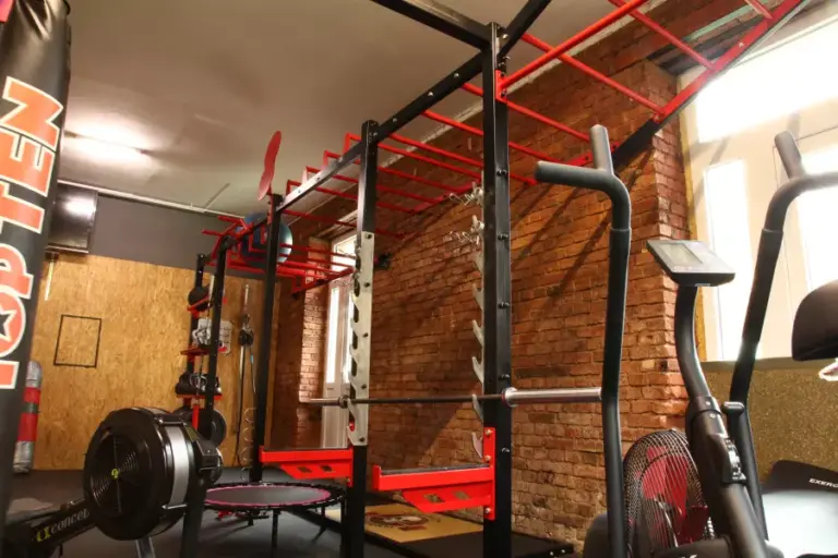 Fitnessstudio neben der Ferienwohnung Plauen: Workout-Bereich mit Klimmzugstation, Rudergerät und Backsteinwand